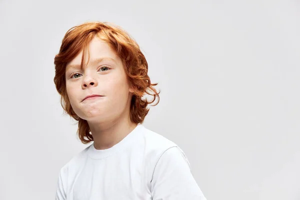 Rothaariges Kind in weißem T-Shirt mit geschlossenen Lippen — Stockfoto