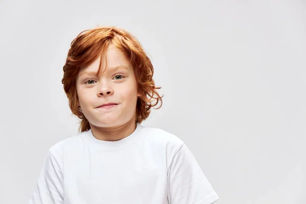 Leuke roodharige jongen in wit t-shirt studio glimlach — Stockfoto