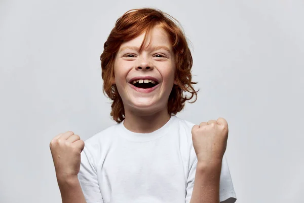 Glada rödhåriga pojke gestikulerar med händerna leende barndom glädje — Stockfoto