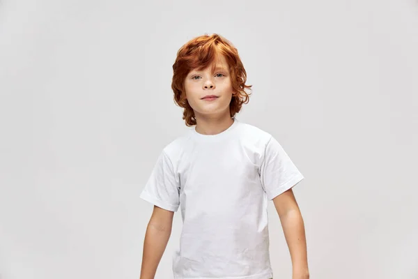 Redhead teenager in white t-shirt cropped view gray background studio — Stock Photo, Image