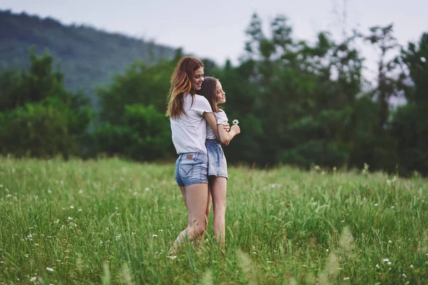 Mamma och dotter i ett fält av blommor gå kul — Stockfoto