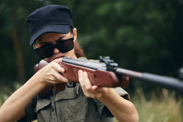 Elinde silah olan asker kadın, güneş gözlüğü silahlarını avlıyor. — Stok fotoğraf
