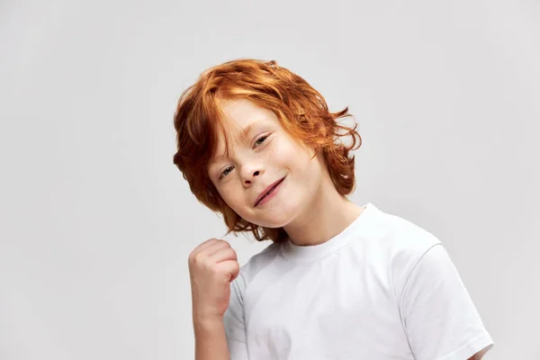 Glimlachende roodharige jongen ogen wit t-shirt bijgesneden bekijk emoties studio — Stockfoto