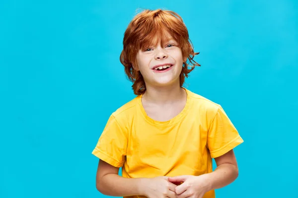 Glad rödhårig tonåring med rött hår och en gul t-shirt skrattar — Stockfoto
