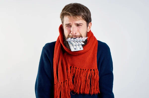 Хлопець з таблетками в роті і червоним шарфом на ізольованому тлі — стокове фото