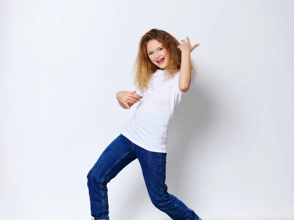 Emotional cheerful girl in a white T-shirt and jeans is gesturing with her hands — Stock Photo, Image