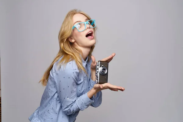 Емоційна жінка з камерою в руках в блакитних окулярах і сорочка нахилила голову назад — стокове фото