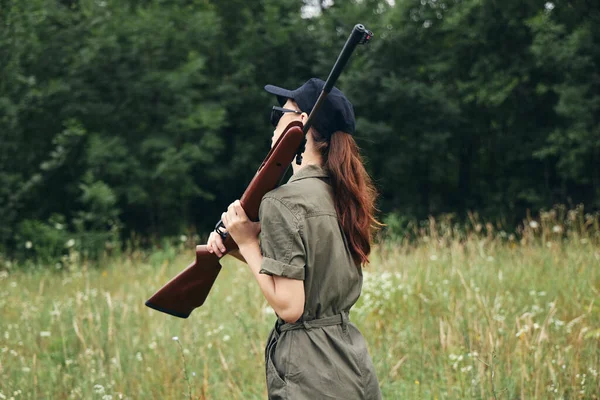 Woman holding a gun in his hands rest walk green overalls