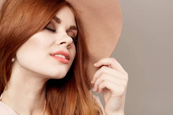 Mulher de cabelos vermelhos em chapéu e camisa no fundo bege maquiagem sorriso charme juventude moda — Fotografia de Stock