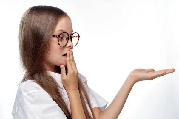Lány fehér ing és szemüveg gesztusok kézzel érzelmek fény háttér stúdió — Stock Fotó