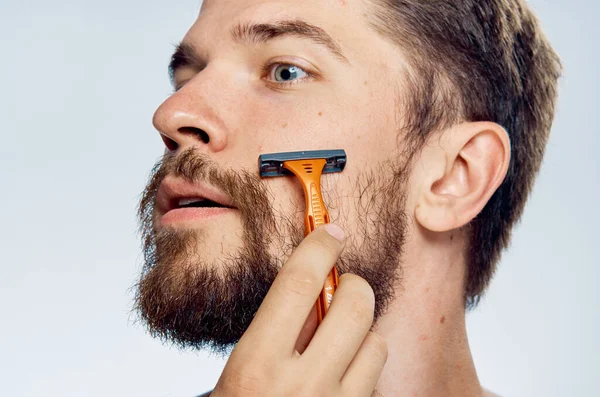 Hombre con afeitadora en barba de mano cuidado de la piel facial estilo de vida de la mañana piel limpia — Foto de Stock
