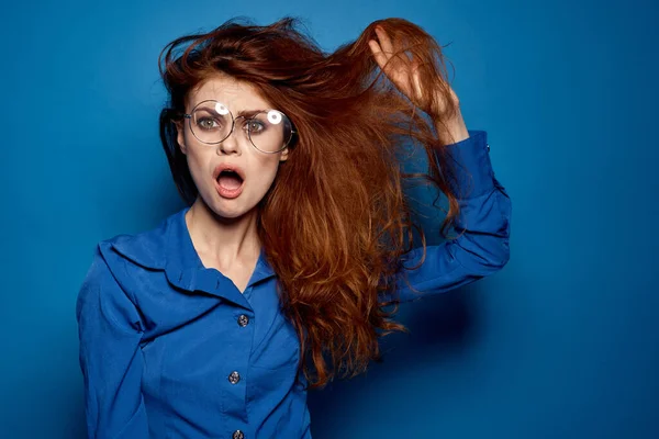 Energetische rothaarige Frau im blauen Hemd mit Brille, die mit den Händen gestikuliert — Stockfoto