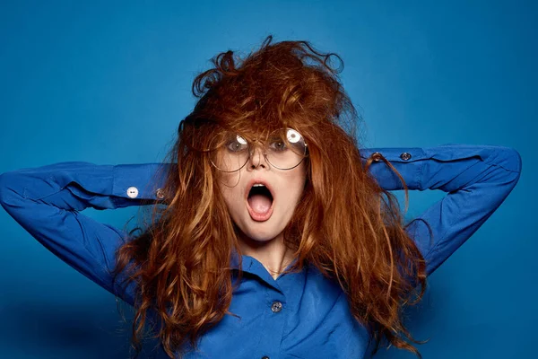 Energetische rothaarige Frau im blauen Hemd mit Brille, die mit den Händen gestikuliert — Stockfoto