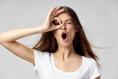 Kadın gözlerinin yanında el ele tutuşuyor ağız açık duygu beyaz tişört 