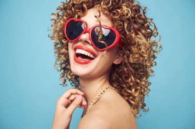 Mavi arka planda çekici kız cazibesi, kırmızı güneş gözlüğü. 