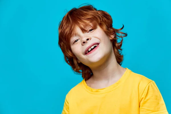 Niño de pelo rojo inclinó la cabeza hacia un lado de una camiseta amarilla — Foto de Stock