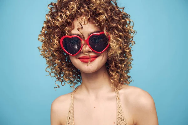 Atraktivní dáma půvab na izolovaném modrém pozadí, červené sluneční brýle — Stock fotografie