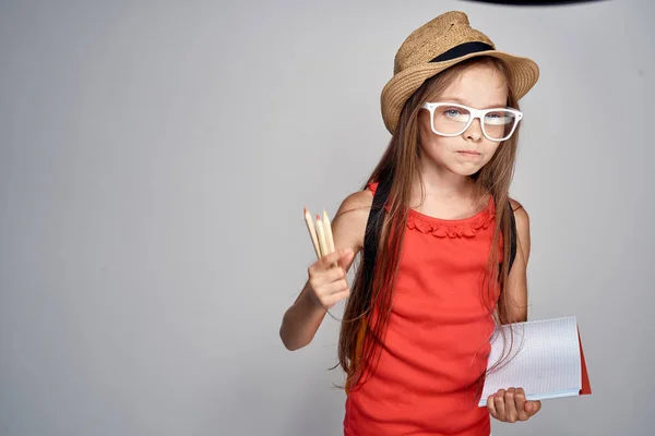 Klein meisje dragen hoed schoolmeisje leren onderwijs rood t shirt — Stockfoto