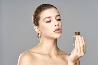 Parfüm şişeli güzel bir kadının portresi. 