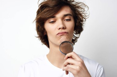 Stüdyoda büyüteçle genç yakışıklı bir adam.