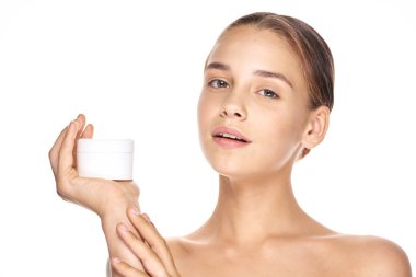 Güzel bir kadının portresi, izole edilmiş arka planda güzellik ürünü taşıyor.