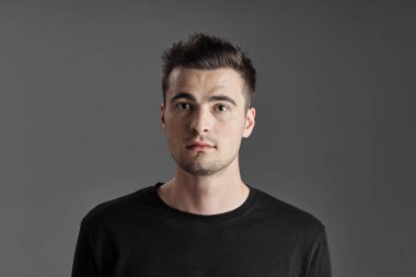 Stüdyoda poz veren yakışıklı genç adamın portresi. 