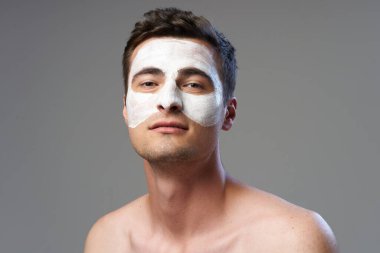 Yüzüne maske takan genç bir adam. Stüdyo çekimi