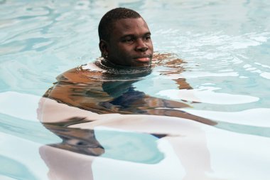 Havuzda poz veren genç yakışıklı adam.