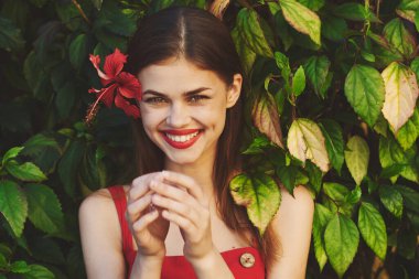 Bahçesinde kırmızı çiçekli güzel bir kadın.                          