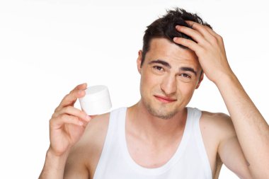 Güzellik ürünleriyle izole edilmiş genç yakışıklı adam. 