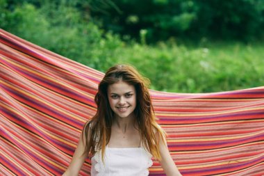 Genç ve güzel bir kadın hamakta dinleniyor. 