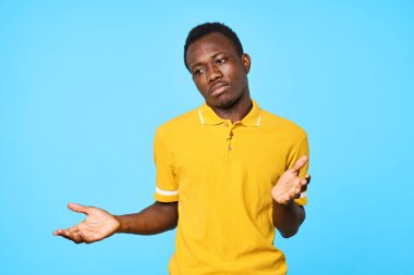 Stüdyoda poz veren yakışıklı genç adam mavi arka planda izole edilmiş.