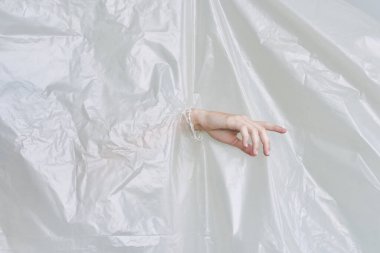 Kadın eli plastiği yırtıyor, polietilen.