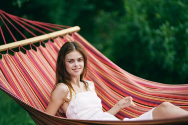 Genç ve güzel bir kadın hamakta dinleniyor. 