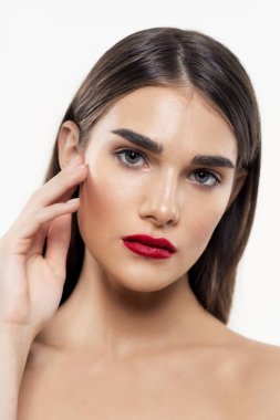 Stüdyo çekimi. Genç ve güzel bir kadın yalnız başına kameraya bakıyor.