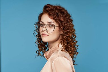 Stüdyoda poz veren gözlüklü güzel bir kadın.