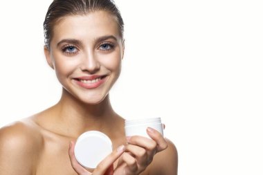 Güzel bir kadının portresi, izole edilmiş arka planda güzellik ürünü taşıyor.