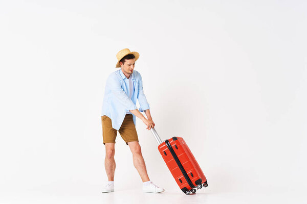 Studio shot of young man tourist  with suitcase