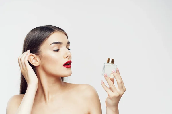 portrait  of young beautiful woman with perfume bottle  isolated