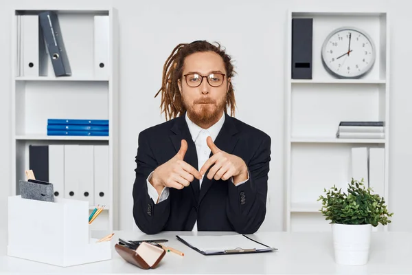 眼鏡をかけた若いビジネスマンがオフィスに座っている — ストック写真