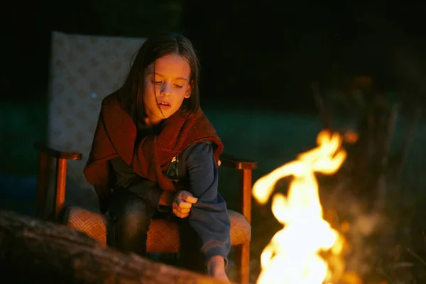 可爱的漂亮姑娘晚上坐在篝火边 — 图库照片