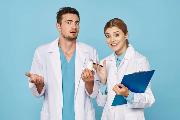 Studio shot. Young  confused doctor and nurse on isolated background
