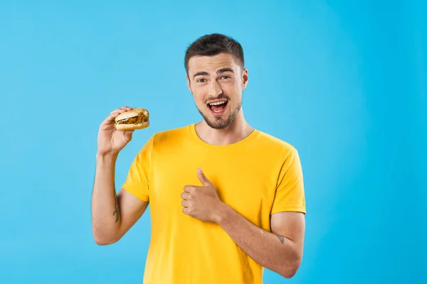 Mladý Pohledný Muž Hamburgery Studiu — Stock fotografie