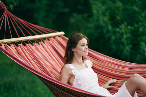 Genç ve güzel bir kadın hamakta dinleniyor. 