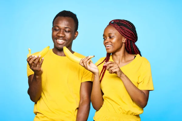 Jovem Casal Bonito Comer Bananas Estúdio Fundo Azul — Fotografia de Stock