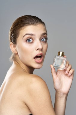 Parfüm şişeli güzel bir kadının portresi. 