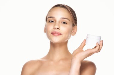 Güzel bir kadının portresi, izole edilmiş arka planda güzellik ürünü taşıyor.