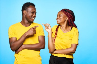 Stüdyoda mavi arka planda poz veren genç ve güzel bir çift