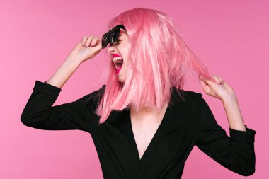 Pembe peruklu ve güneş gözlüklü güzel bir kadın bağırıyor. 