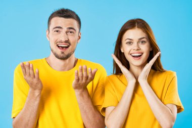  Stüdyoda mavi arka planda genç ve yakışıklı bir adam ve kadın var. 